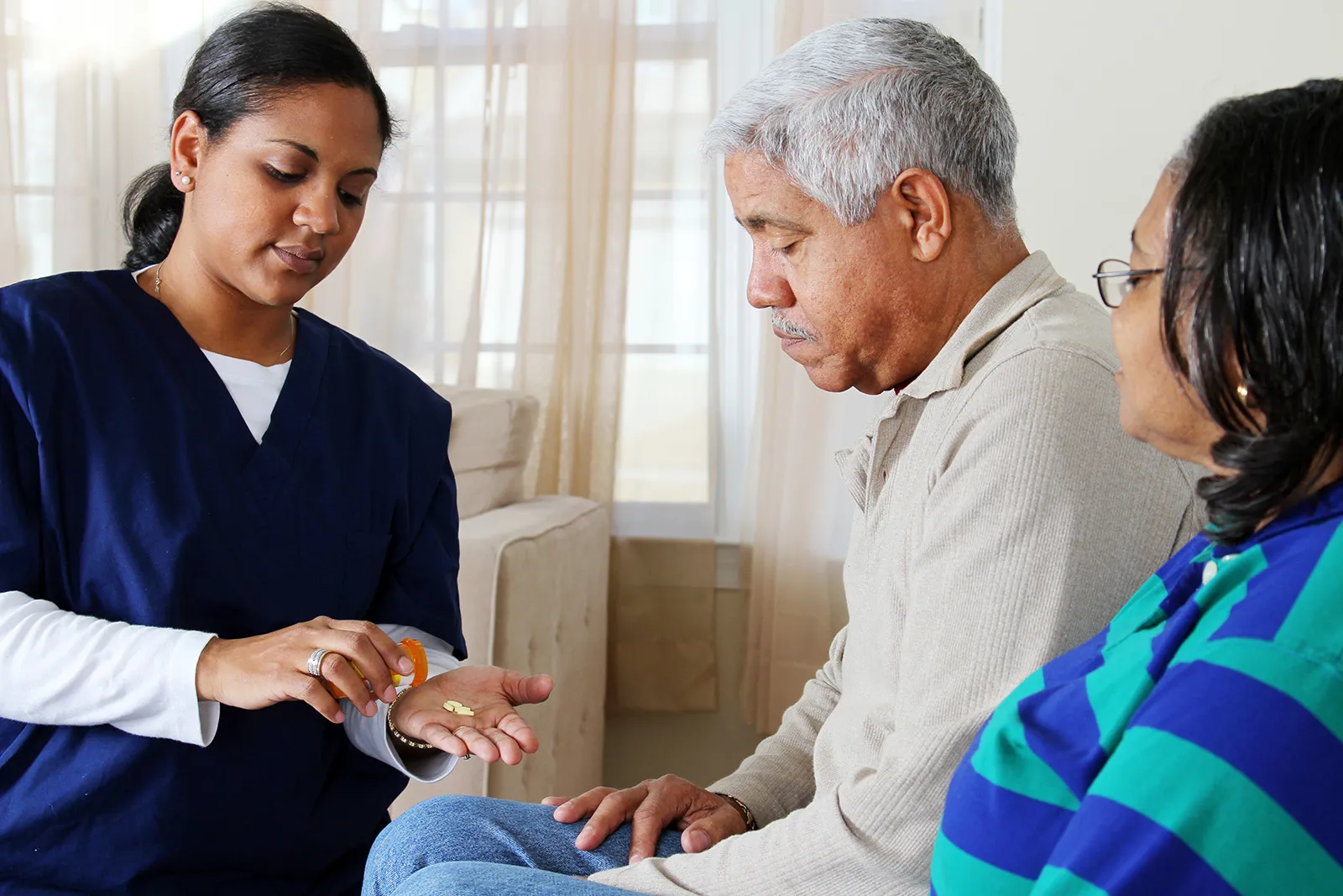 Health worker measures medication for older couple