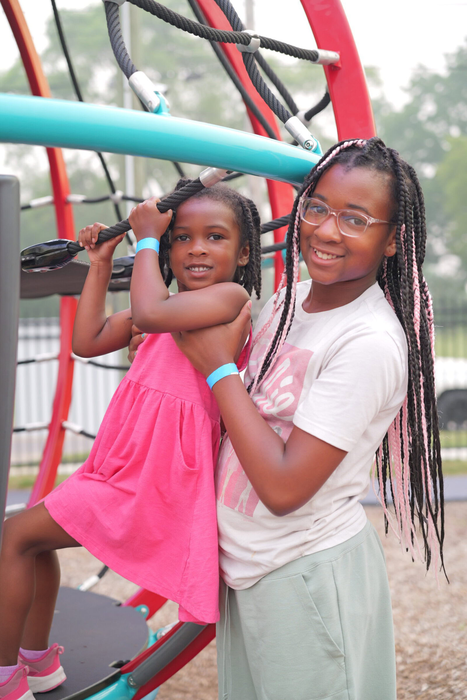 A parent and child playing together on playground equipment in their neighborhood