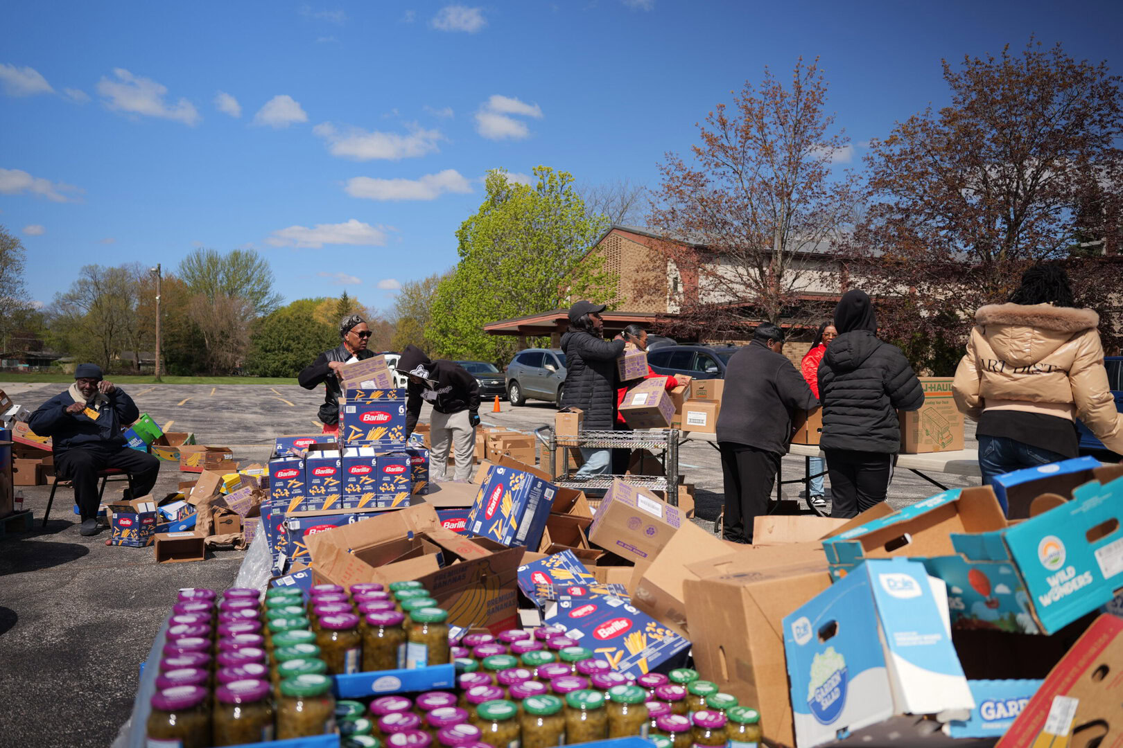 Community volunteers organizing food donations at an outdoor distribution event